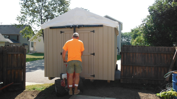 Moving storage shed through tight space in backyard